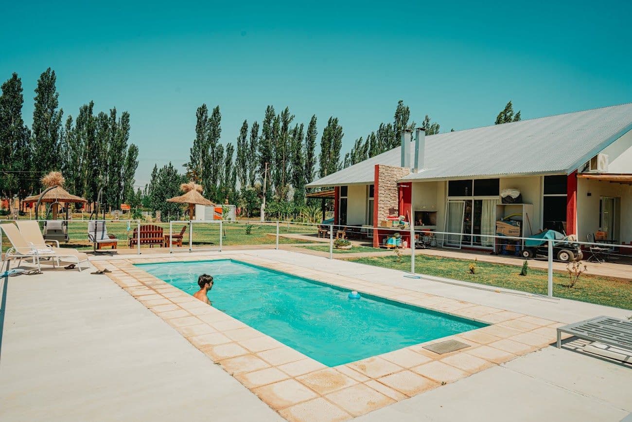 Pileta con las cabañas de fondo